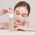 Person holding NEOGEN Real Heartleaf Soothing Essence 150ml bottle close up.