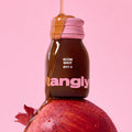 NOTHING BETTER Tangly Glow Shot 7 Bottles featuring a vibrant design with pomegranate on a pink background.