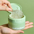Person holding a NUTSELINE Cica Calming Pad container with open lid and visible calming pad inside.