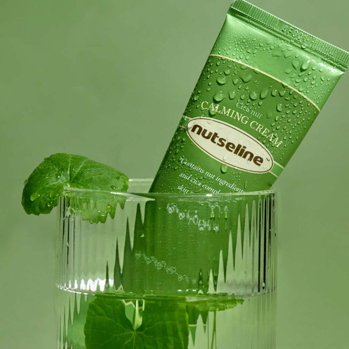 NUTSELINE Cica Nut Calming Cream 60ml in a decorative glass with leaves, emphasizing the soothing and natural qualities of the skincare product.