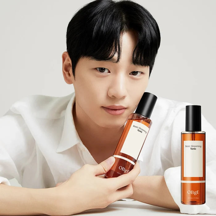 Gentleman Korea model holding OBGE Basic Grooming Tonic 210ml bottle in minimalist studio shot for men's skincare