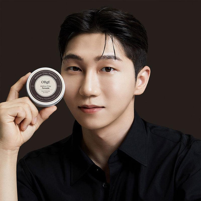 OBGE Mellow Clay Pomade 100g held by a Korean gentleman model in black shirt for Gentleman Korea, premium men’s styling clay pomade