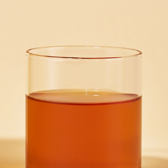 Glass of OSULLOC Vanilla Honey Black Tea 20 P showcasing its rich amber color against a neutral background