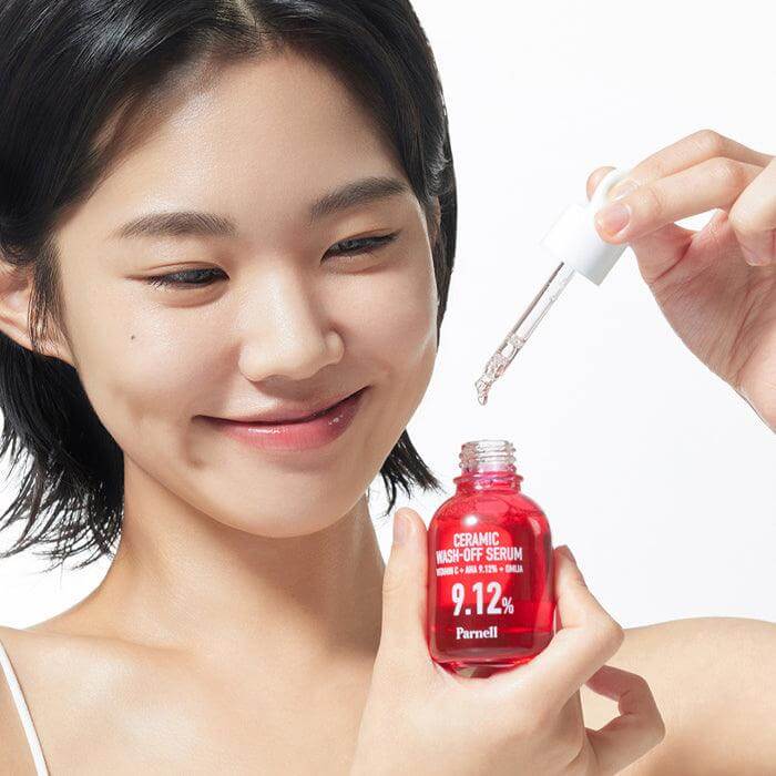Woman applying PARNELL AHA 9.12 Caremic Wash-Off Serum 30ml from bottle using dropper.