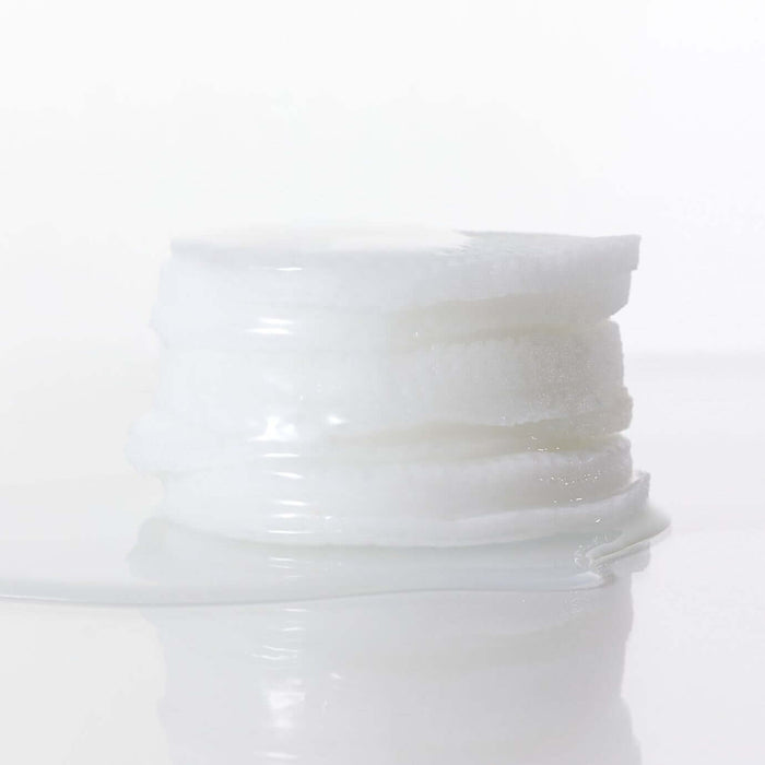 Stack of skincare pads from PARNELL Niacinamide Rice Brightening 60 pads product line on a reflective surface.