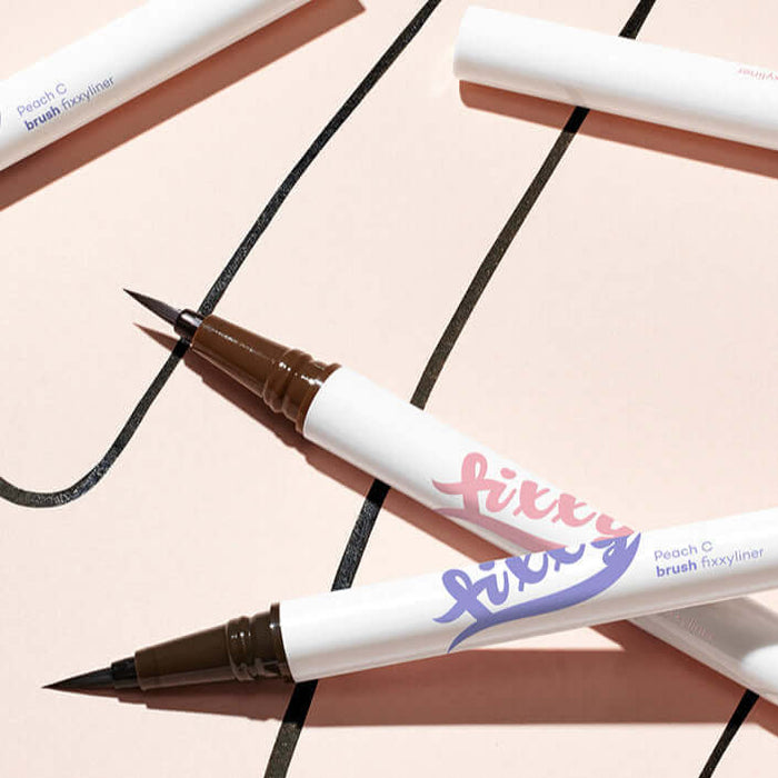 Close-up of PEACH C Brush Pixie Liner with intricate brush design on a light background.