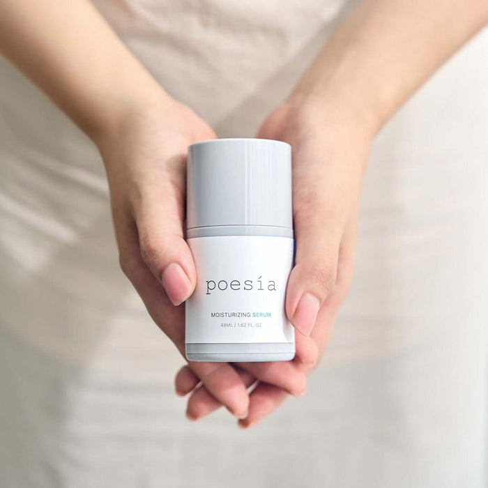 Hands holding POESÃA Hydro Hyaluronic Deep Moisturizing Ampoule Serum 48ml bottle.