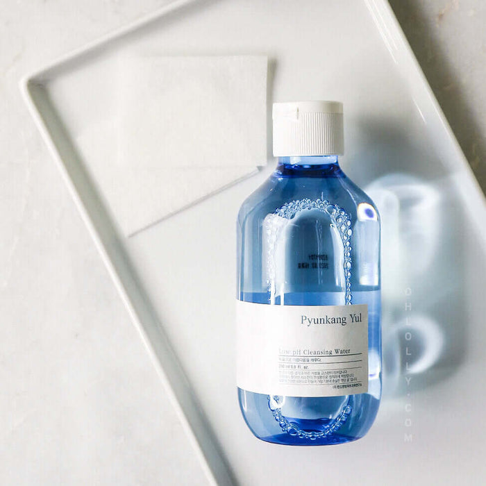 PYUNKANG YUL Mildly Acidic Cleansing Water 290ml bottle on a white tray with cotton pad
