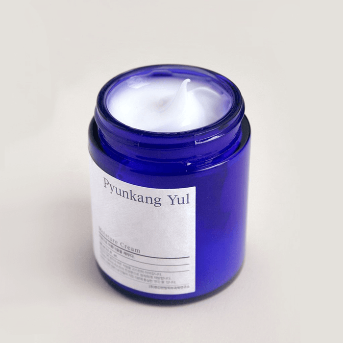 Open jar of PYUNKANG YUL Moisture Cream 100ml with white cream inside and blue container.