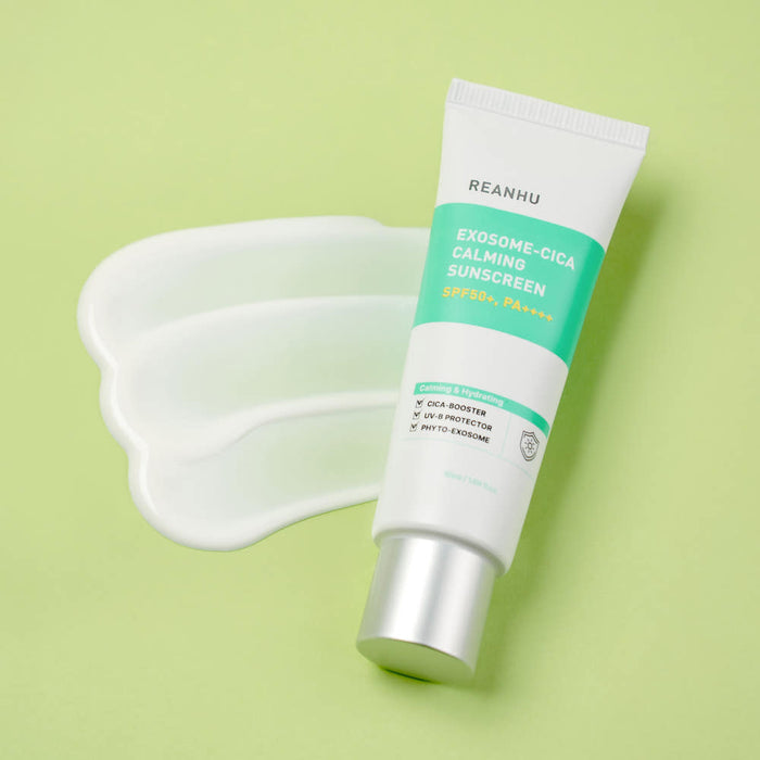 REANHU Exosome Cica Calming Sunscreen 50ml tube on green background with sunscreen swatch — Gentleman Korea men's K-beauty SPF protection