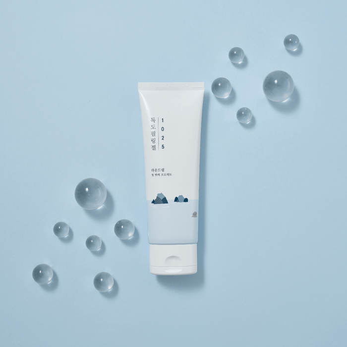 ROUND LAB 1025 Dokdo Peeling Gel 120ml product on blue background with decorative clear spheres.