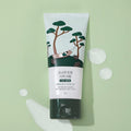 ROUND LAB For Men Pine Calming Cica Cream 75ml tube on green background with cream drops, Gentleman Korea men's soothing skincare product