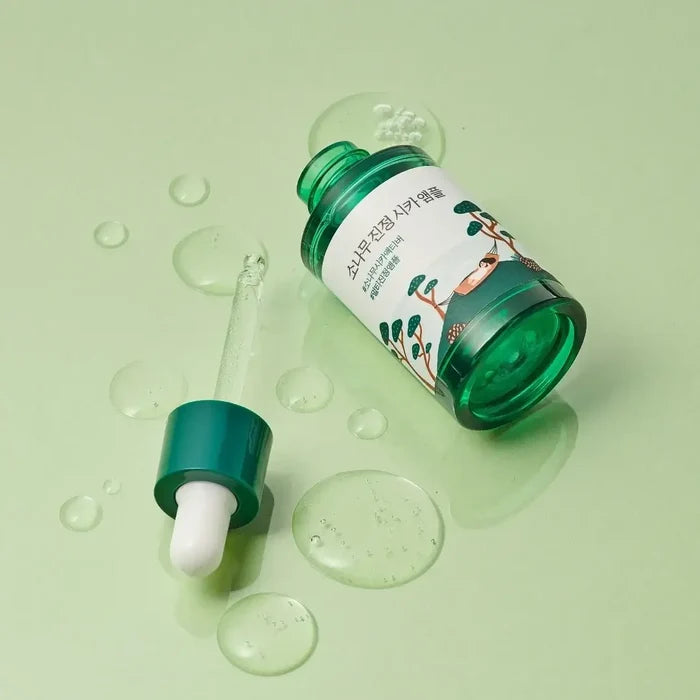 ROUND LAB Pine Calming Cica Ampoule 30ml bottle with dropper on a green background