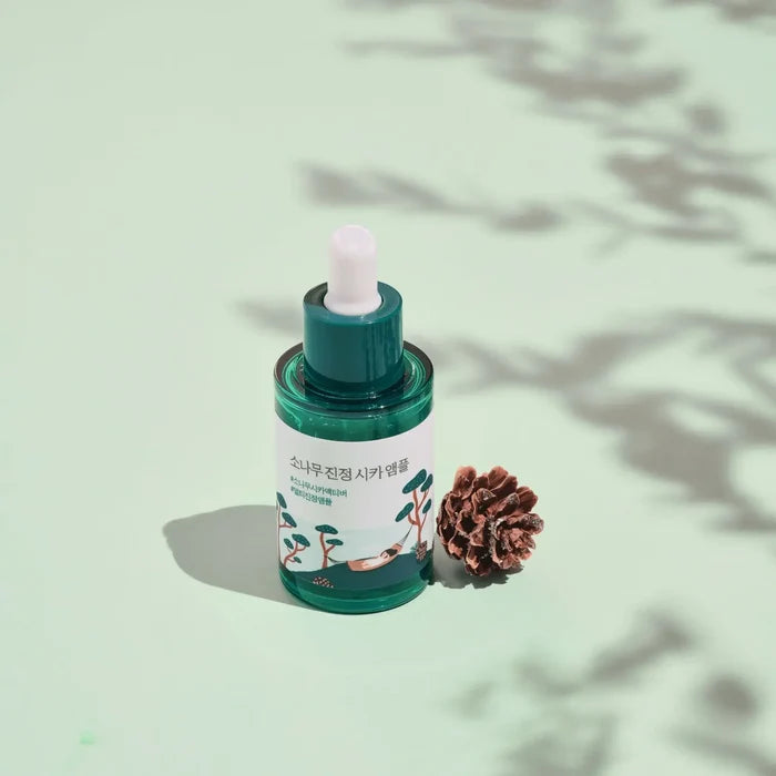 ROUND LAB Pine Calming Cica Ampoule 30ml with pine cone on pastel green background