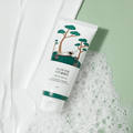 Image of ROUND LAB Pine Calming Cica Cleanser 150ml with soothing pine tree design on a green and white textured background.