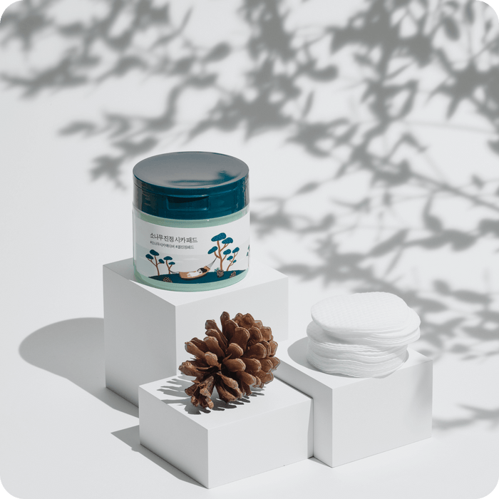 ROUND LAB Pine Calming Cica Pads 50 sheets displayed with pine cone on white blocks for soothing skincare