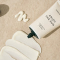 SHAISHAISHAI Enjoy The Sun UV Protection Cream SPF50 50ml tube on sand background with cream application