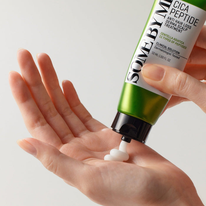 Applying SOME BY MI Cica Peptide Anti Hair Loss Derma Scalp Treatment 50ml from tube to hand for hair care