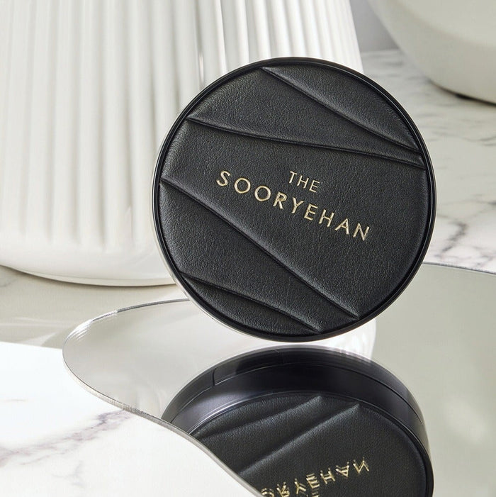 SOORYEHAN The Black Tension Fit Mesh Cushion 13g on a marble surface, reflecting elegance and luxury in design.
