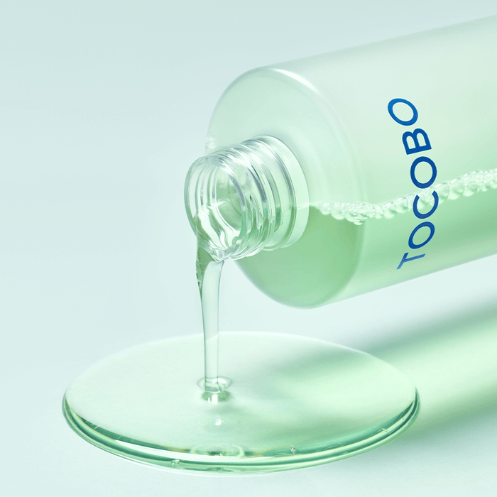 TOCOBO Cica Calming Aqua Toner pouring from bottle onto flat surface.