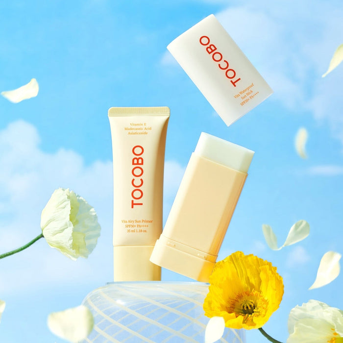 TOCOBO Vita Waterproof Sun Stick displayed with bright flowers against a blue sky background.