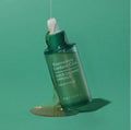 TONYMOLY Quick Calming Ampoule 50ml on green background with liquid spill