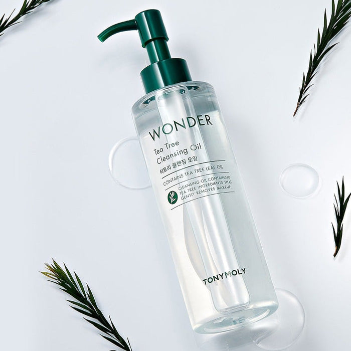 TONYMOLY Wonder Tea Tree Cleansing Oil 200ml bottle with green pump, surrounded by tea leaves on white background.