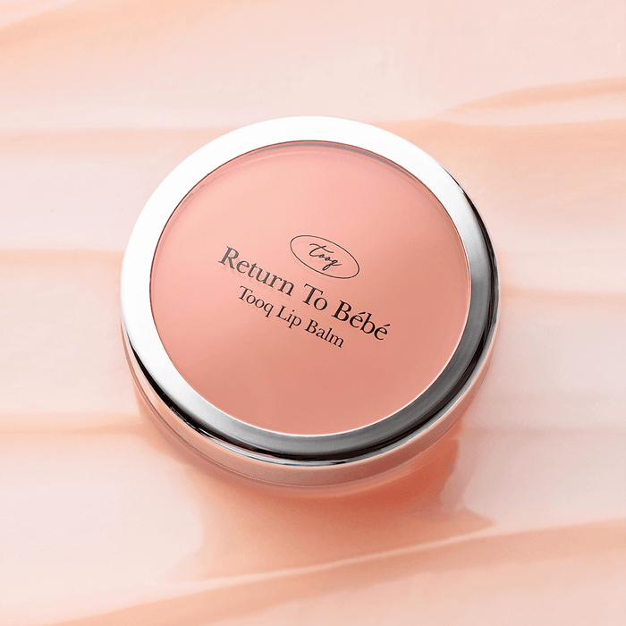 TOOQ Return To BÃ¨bÃ¨ Lip Balm in round container on peach background