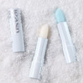UNLEASHIA Glacier Vegan Lip Balm in snowy background showcasing two open lip balms with icy colors.