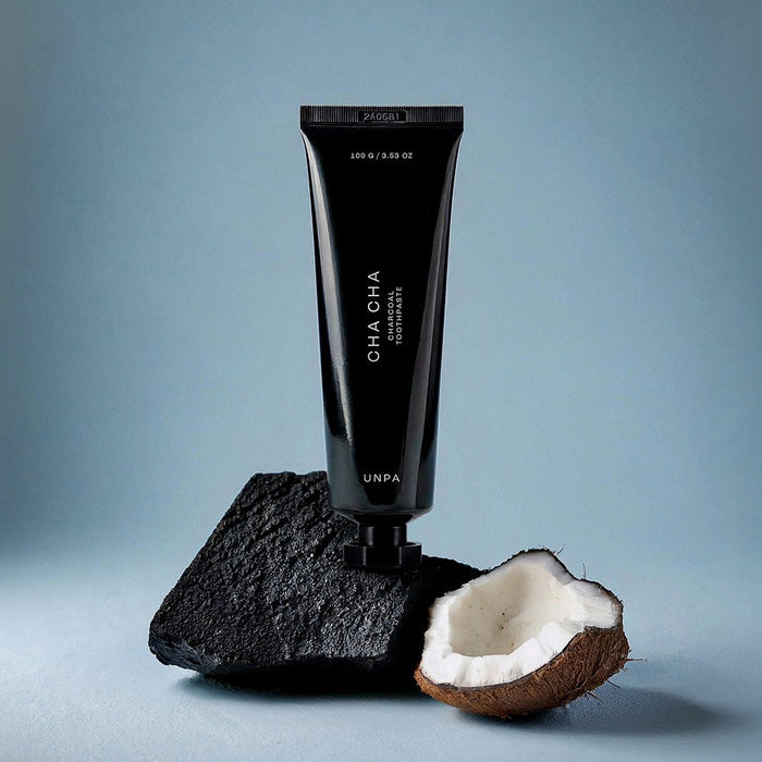 UNPA Cha Cha Charcoal Original Toothpaste 100g tube with charcoal and coconut on blue background
