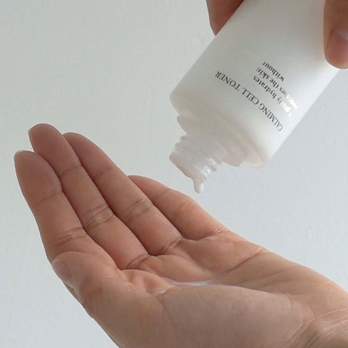 Person pouring XOUL Calming Cell Toner 130ml into their hand, showcasing the product's application.
