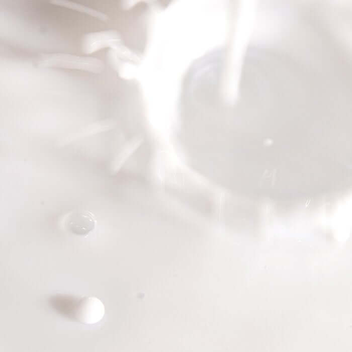 Texture of XOUL Calming Cell Toner 130ml with splashes on a white background.